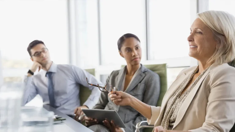 Photo of business leader at a conference table with colleagues.