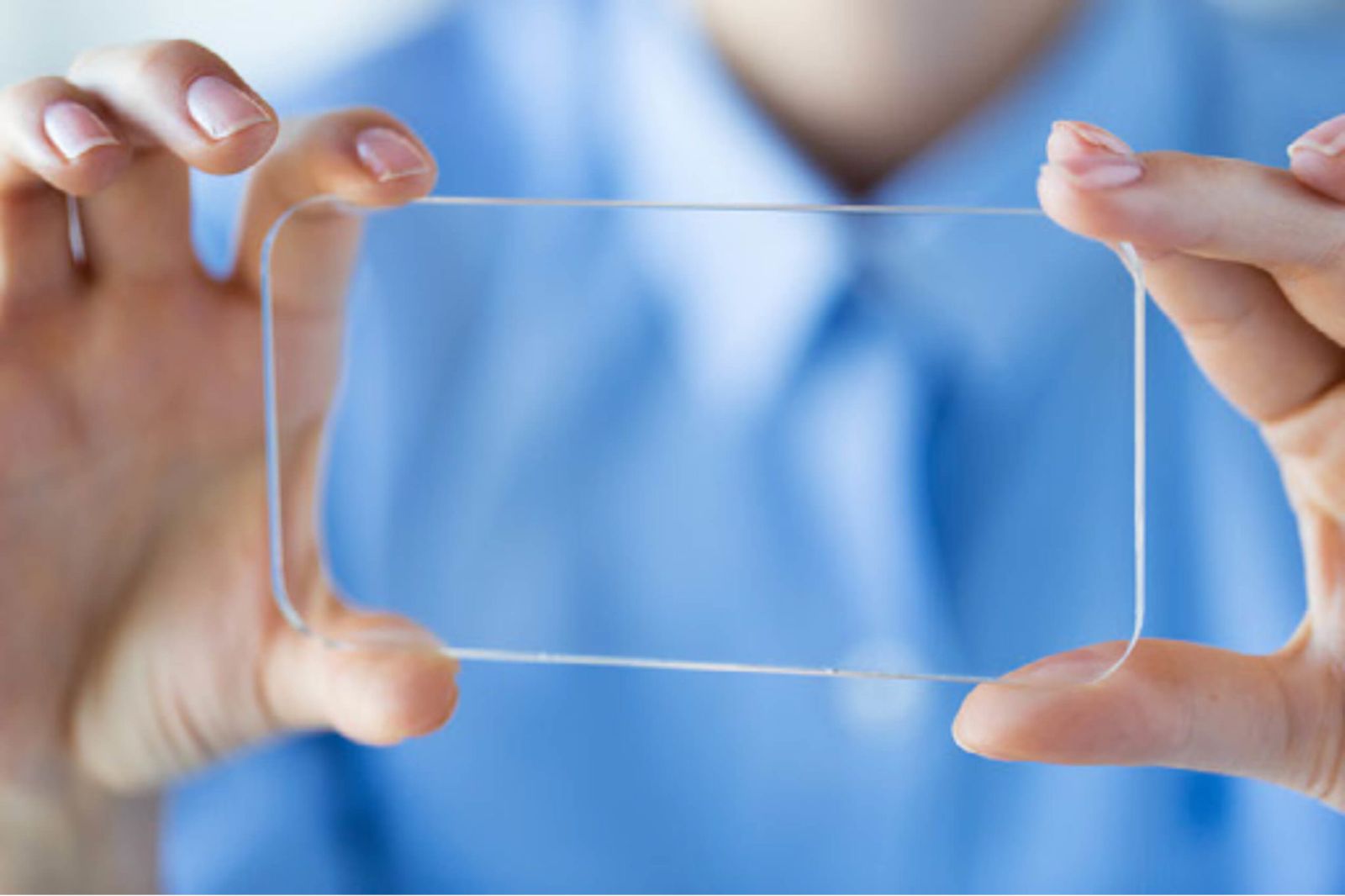 Close-up of a person's hands holding up a clear rectangle to represent transparency. transparency.