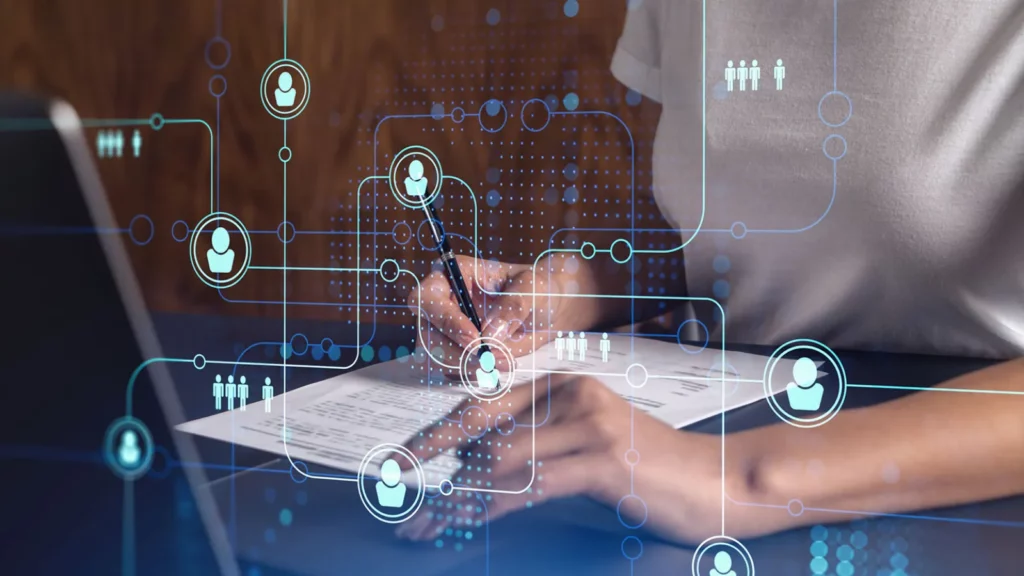 Photo of a job candidate writing a resume with tech graphics overlaid on top.