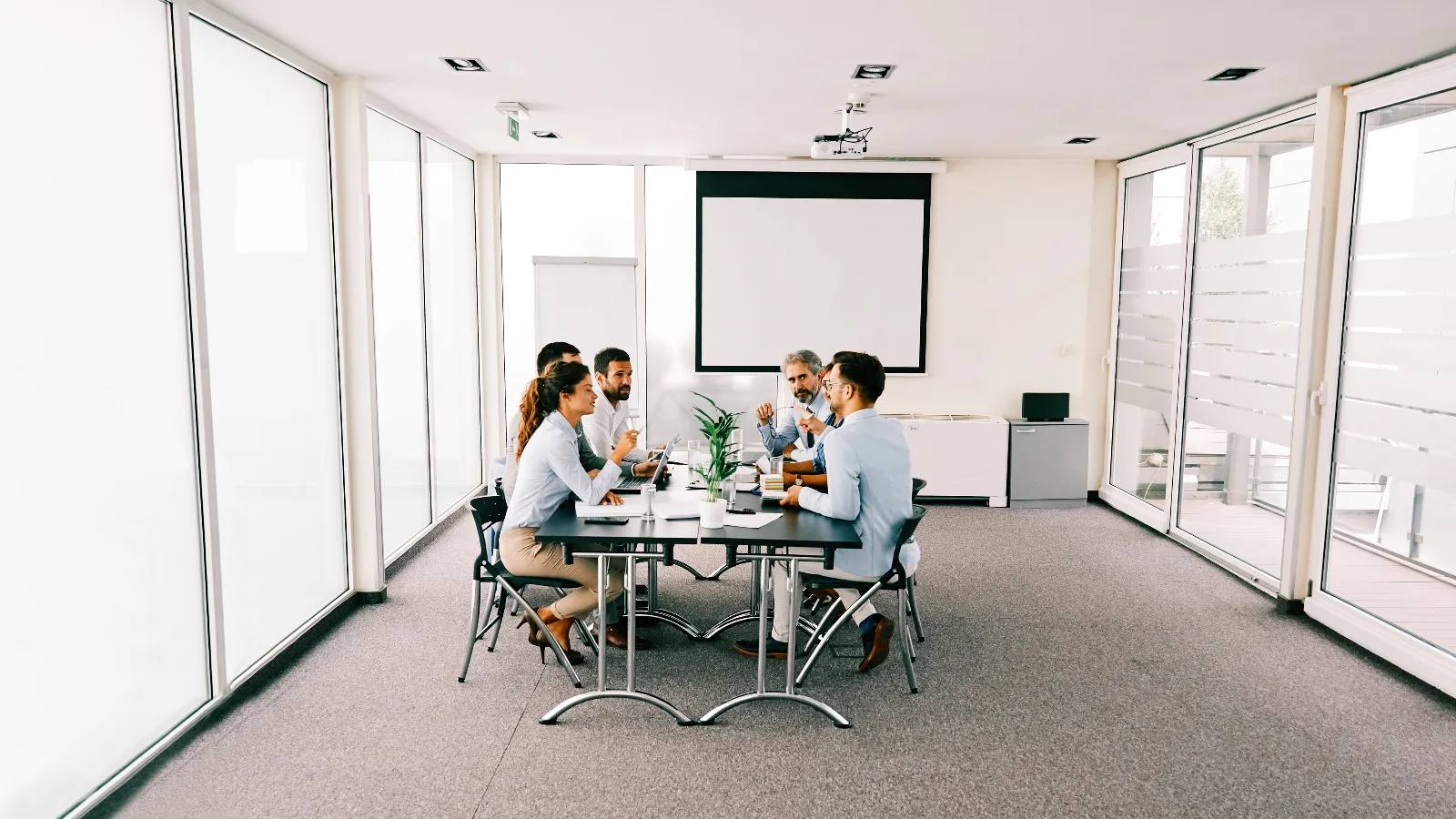 Photo of a work team sitting at a conference table having a discussion.